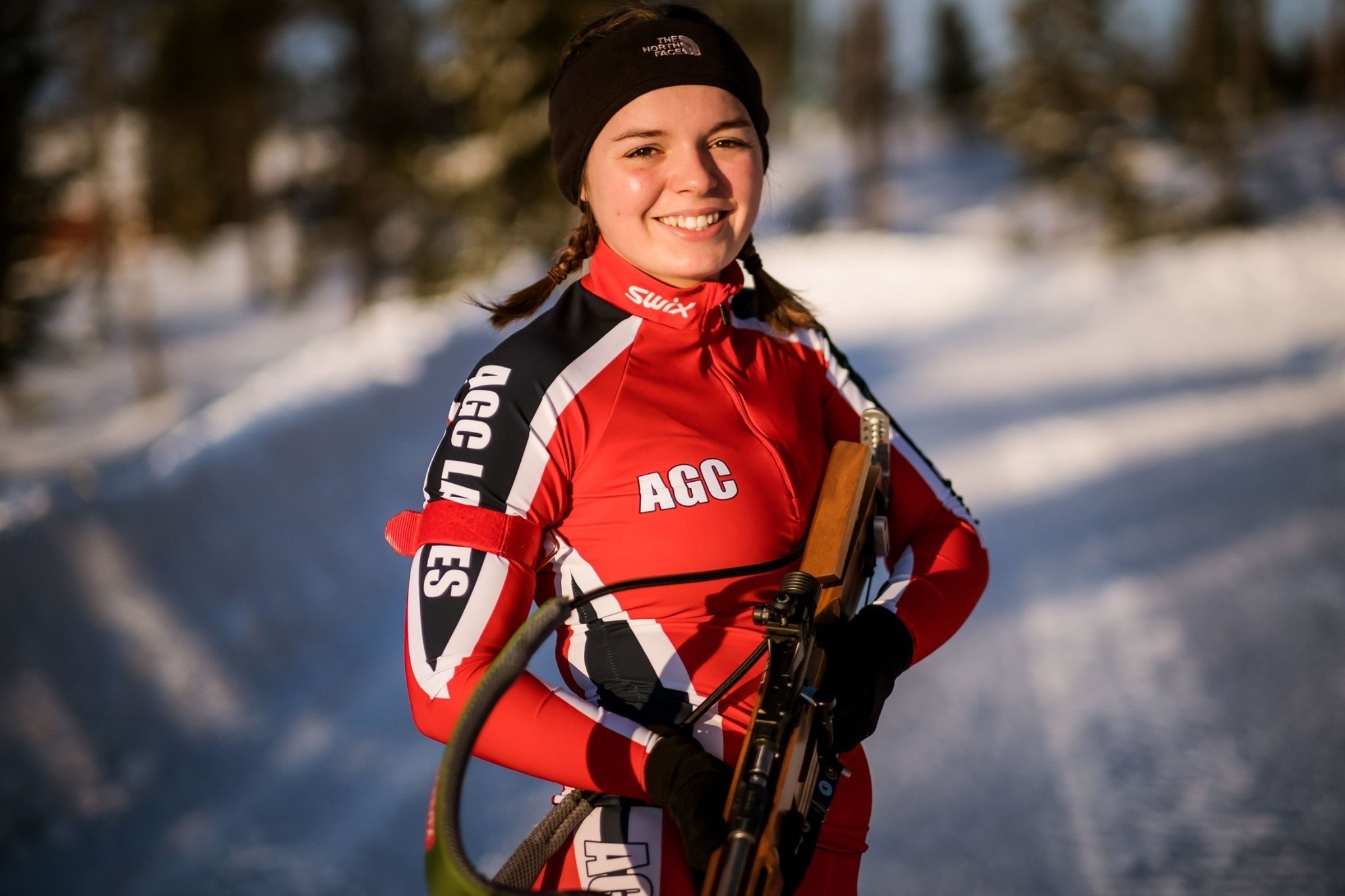 Eden wearing pentathlon gear with ski suit and rifle.
